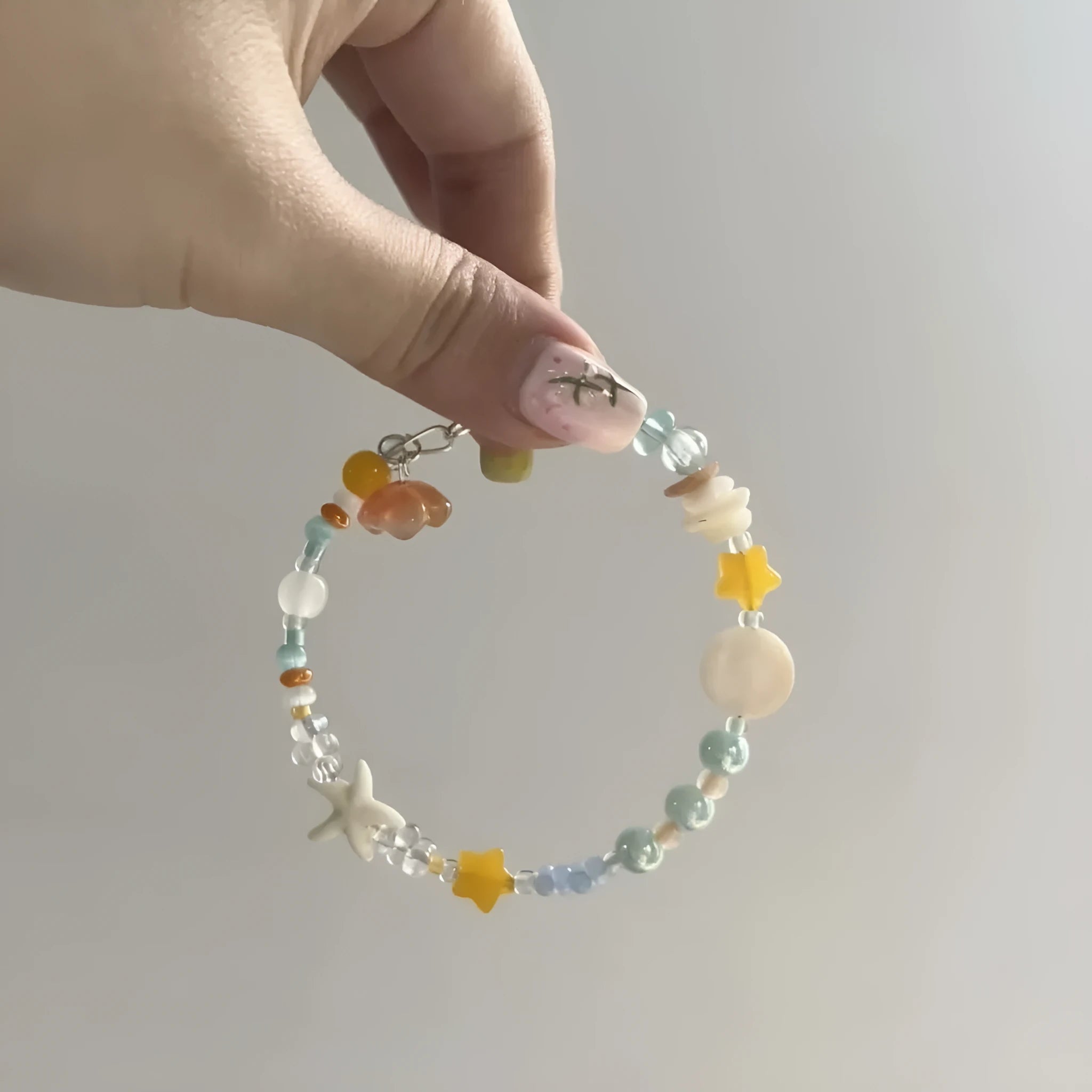 Orange alloy bracelet with diamond shape design and mixed materials for summer seaside wear