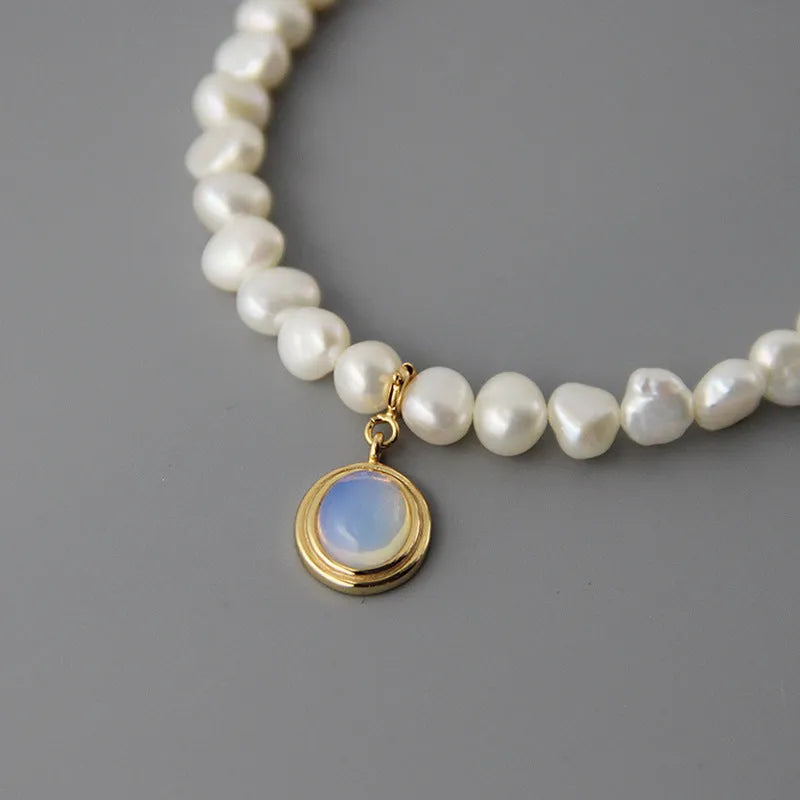 Sterling silver geometric pendant necklace with irregular pearl on adjustable chain.