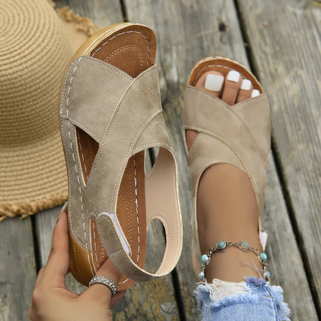Women's brown roman platform sandals with a skirt detail and velcro strap fastening on a white background