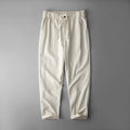 Man wearing solid-colour linen casual trousers in a relaxed setting.