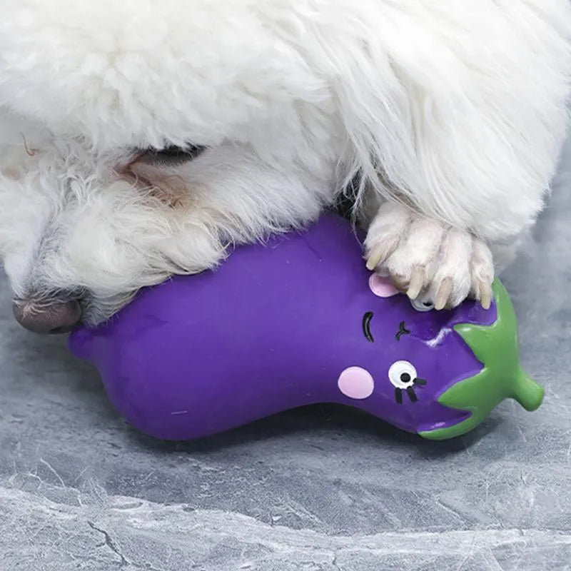 Green latex dog chew toy shaped like a cartoon onion, next to a purple eggplant-shaped chew toy.