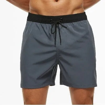 Blue men's fitness shorts with drawstring waist, pockets, and a zipper on a neutral background.