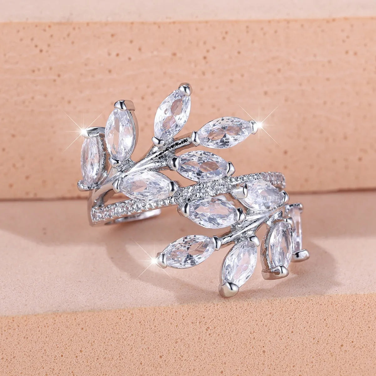 Copper leaf-shaped fashion ring with zircon details and an adjustable opening, shown in a rose gold finish.