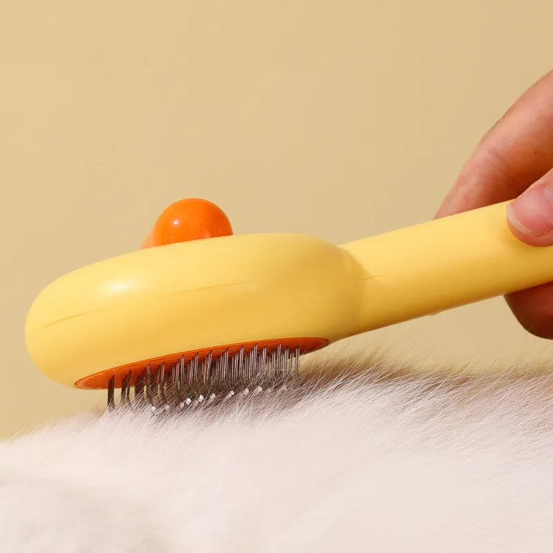 Yellow plastic pet grooming comb with open-section needle teeth for removing hair from cats and dogs.
