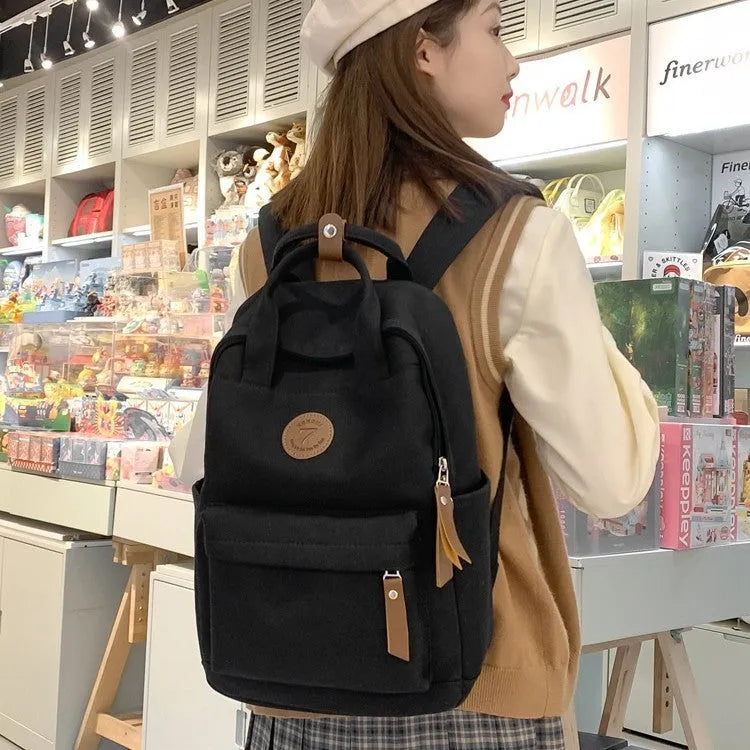 Black Oxford cloth unisex backpack with curved shoulder straps in an urban simplicity style.