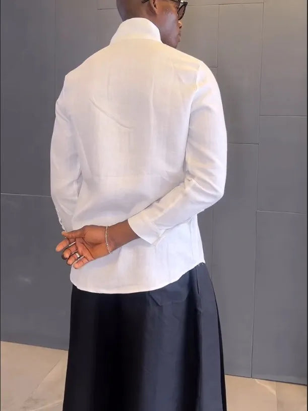 White asymmetric front long sleeve shirt and black pleated trousers co-ordinates set on a hanger