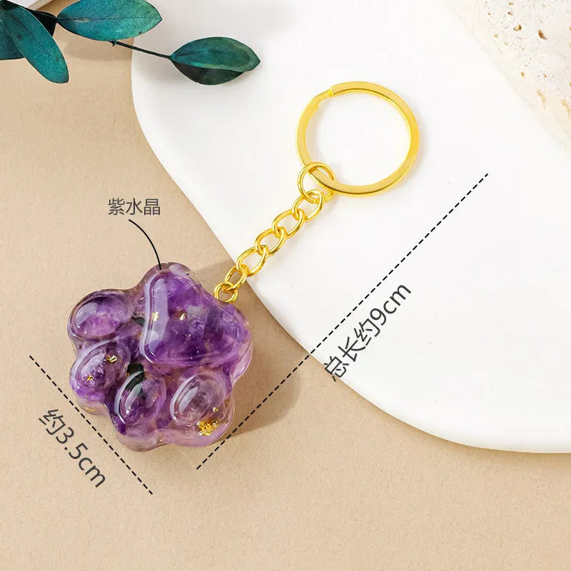 Cat's paw shaped keychain pendant made from a natural crystal gemstone on a keyring.
