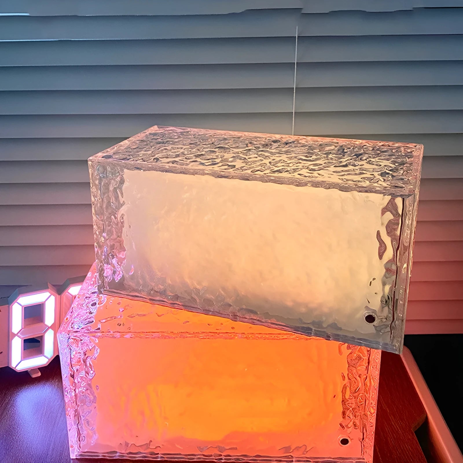 Geometric ice cube-shaped night lamp with coloured lighting on wooden surface