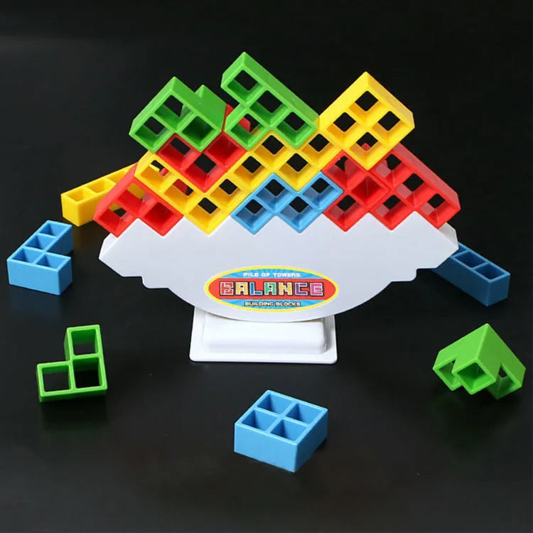 Plastic balance stacking game with 16 coloured blocks, chassis, and base on a table.