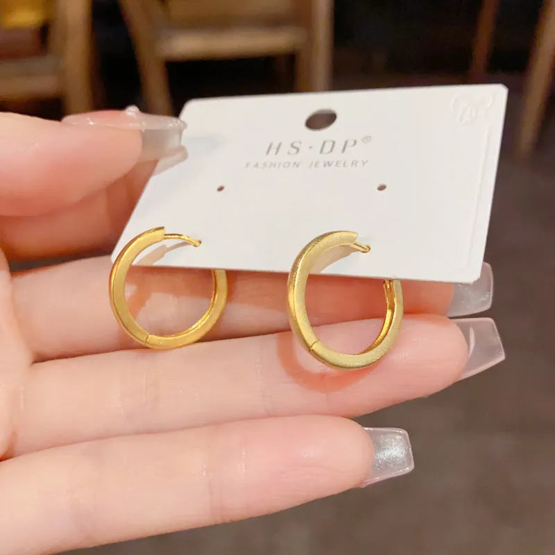 Women's geometric ear clip with round eyelet design in gold plating on copper