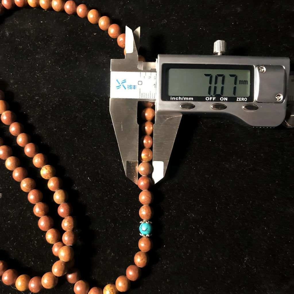 108 bead Lvzhu stone bracelet with 5-6mm geometric beads on wrist