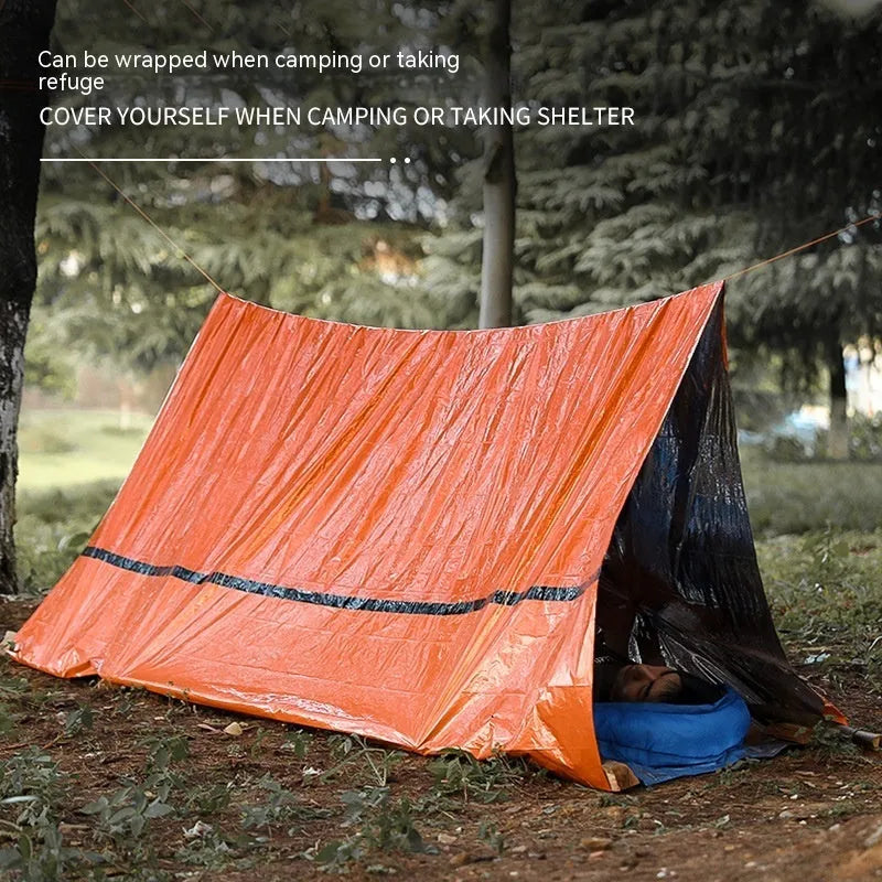 Portable orange disaster relief tent with sleeping bag and emergency blanket for outdoor use