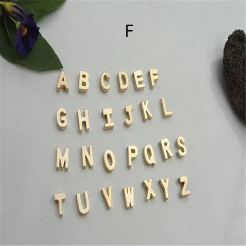Gold heart shaped alloy pendant with initial letter on white background