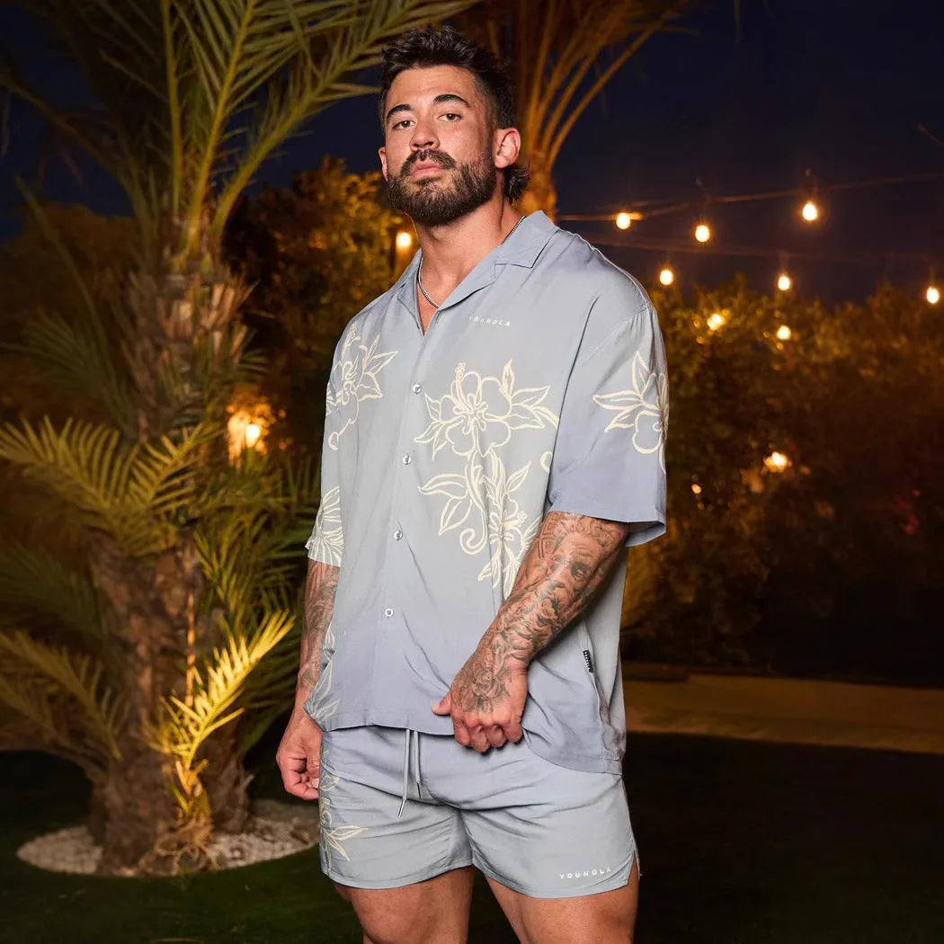 Man wearing a loose-fit, short-sleeve floral print cardigan in a light colour.
