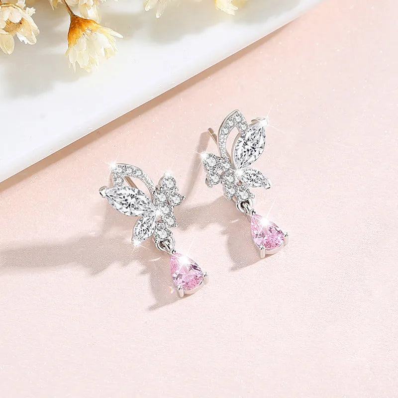 A pair of silver stud earrings featuring a butterfly design with crystal details on a white background.
