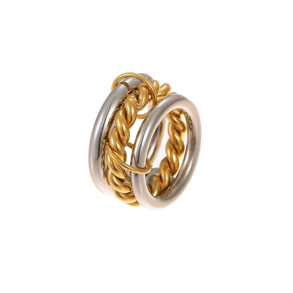 Stacked gold plated stainless steel rings with exaggerated designs on woman's hand