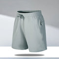Man wearing loose light grey quick-dry polyester beach shorts on summer day