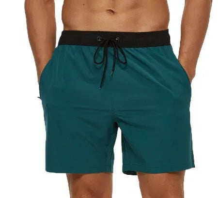 Blue men's fitness shorts with drawstring waist, pockets, and a zipper on a neutral background.