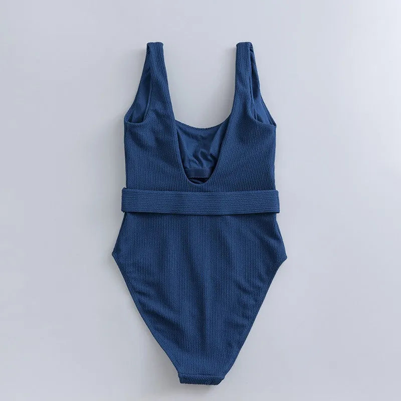 Navy blue women's one-piece triangle swimsuit on a hanger.