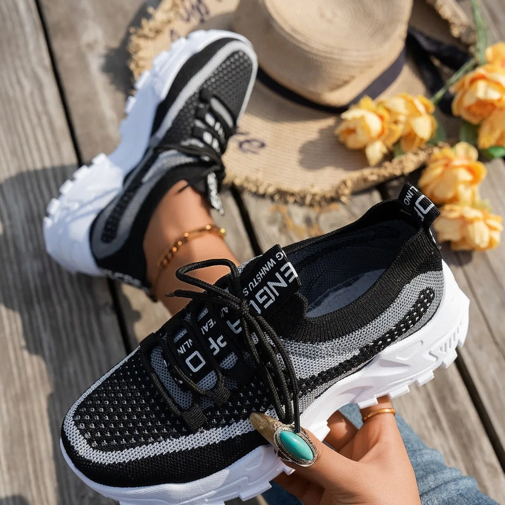 Women's Flyknit mesh lace-up sneakers in a colour option, showing the round toe and rubber sole.