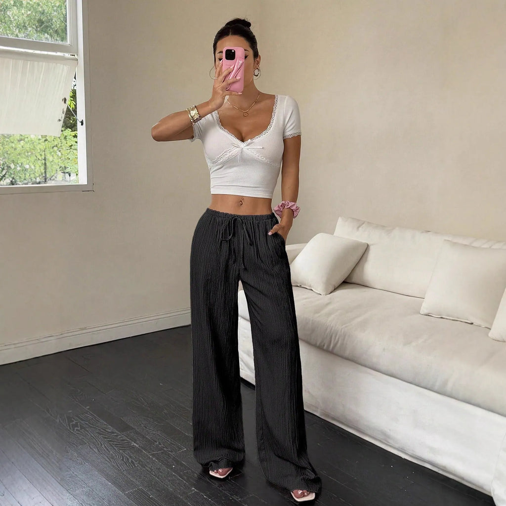 Women's black wide leg trousers with lace-up waist detailing on mid-rise waist