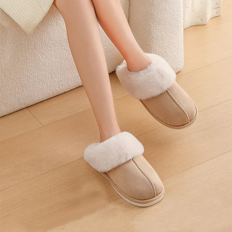Women's plush winter slippers in pink with a round toe, flat heel, and decorative stitching.