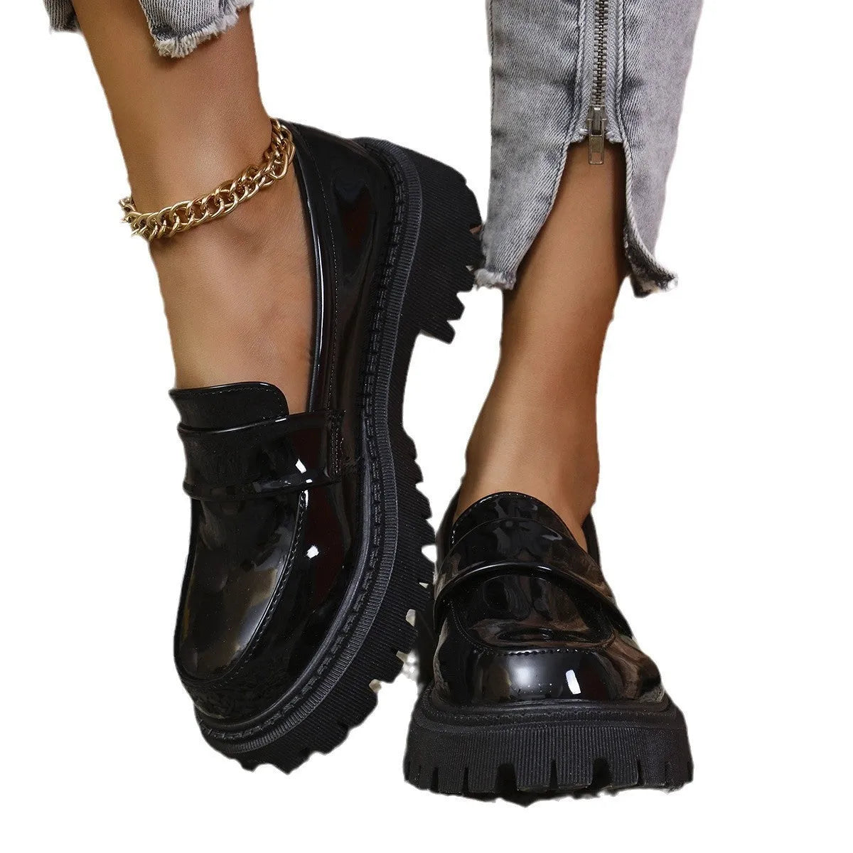 Women's black slip-on loafers with a chunky platform heel on a wooden floor