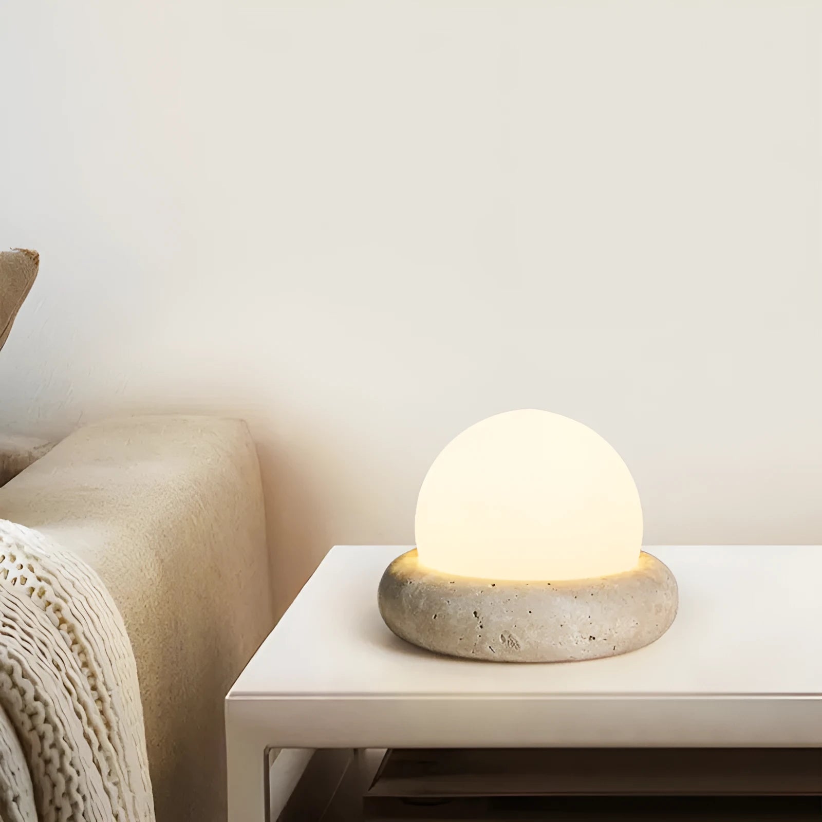 Modern simple bedside night light with remote control on a table.