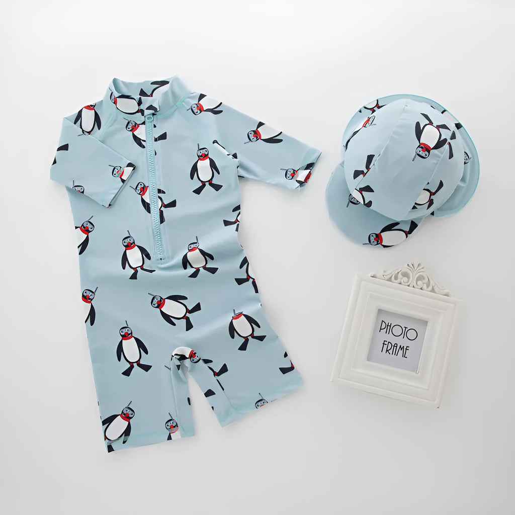 Boy's penguin print long sleeve one-piece swimsuit with matching swimming cap.
