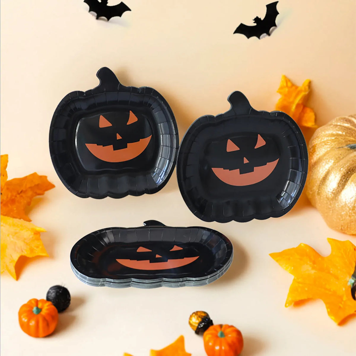 Black pumpkin design disposable paper plates measuring 9 inches in diameter, shown in Halloween party setting.