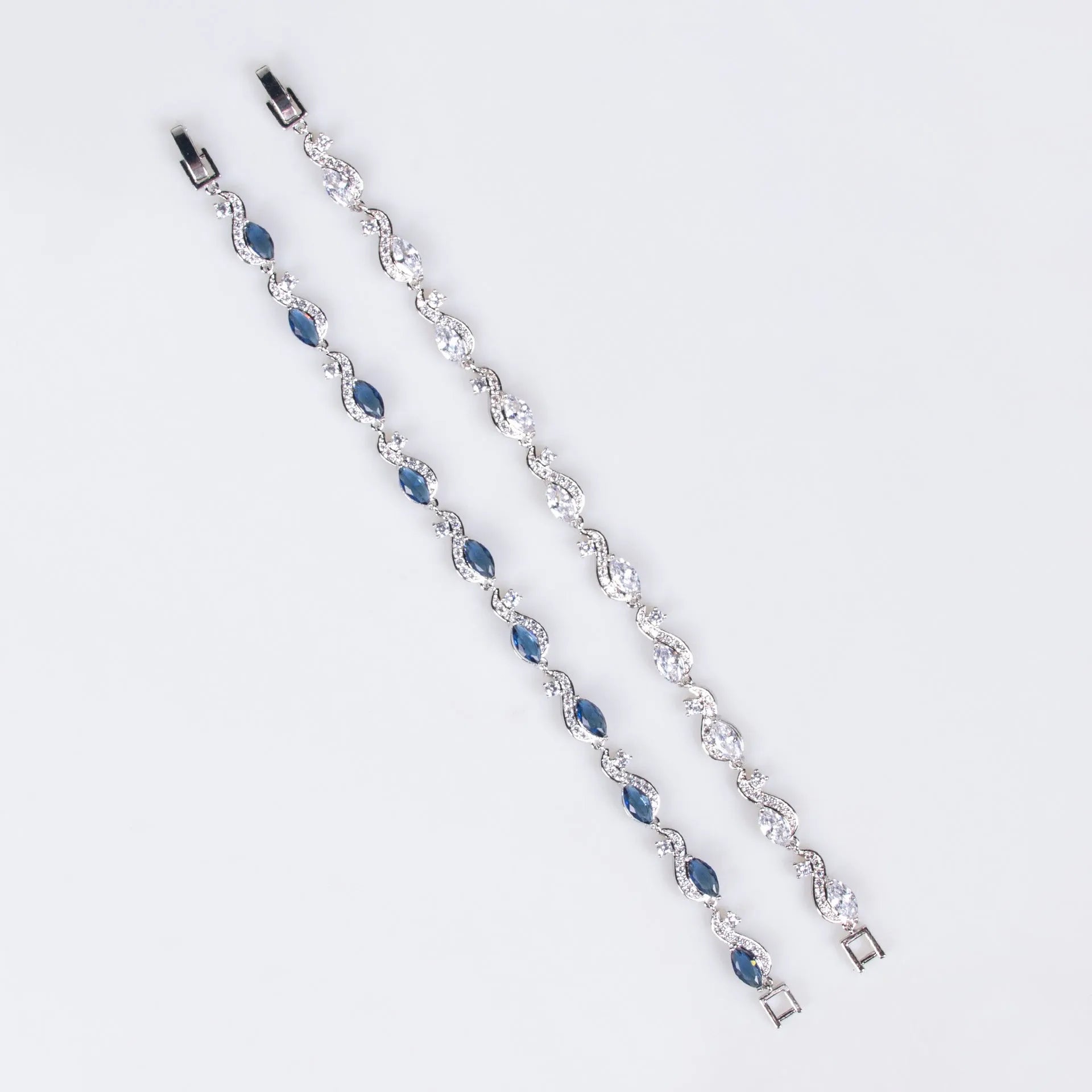 Women's copper geometric line bracelet with inlaid blue zircon stones on a white background