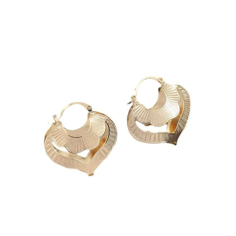 Gold electroplated copper heart-shaped hollow stud earrings with lace-inspired openwork design and geometric round elements