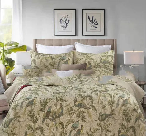Blue botanical patterned quilted cotton bedspread set on a bed, showing plants, flowers, and bird design.