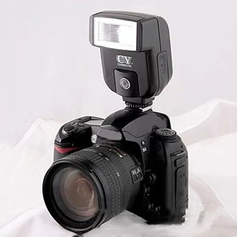 Compact black hot shoe flash unit tilted upwards on a DSLR camera