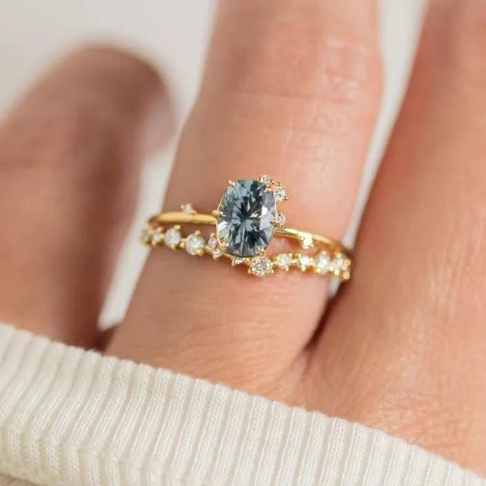Gold-coloured floral fashion ring with a central green zircon stone on a white background.