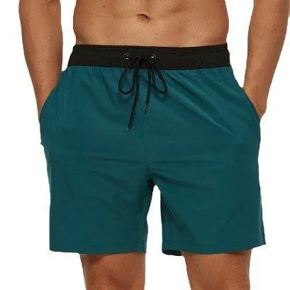 Blue men's fitness shorts with drawstring waist, pockets, and a zipper on a neutral background.