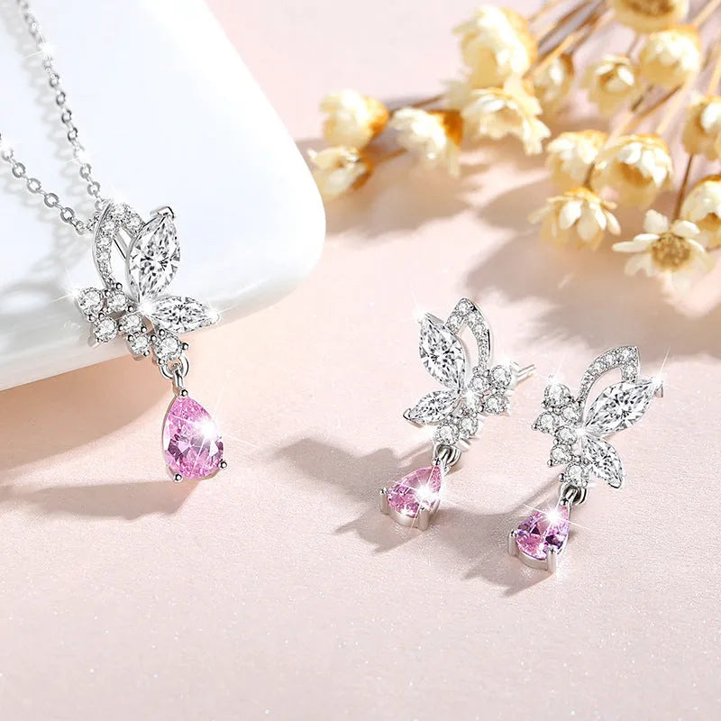 A pair of silver stud earrings featuring a butterfly design with crystal details on a white background.
