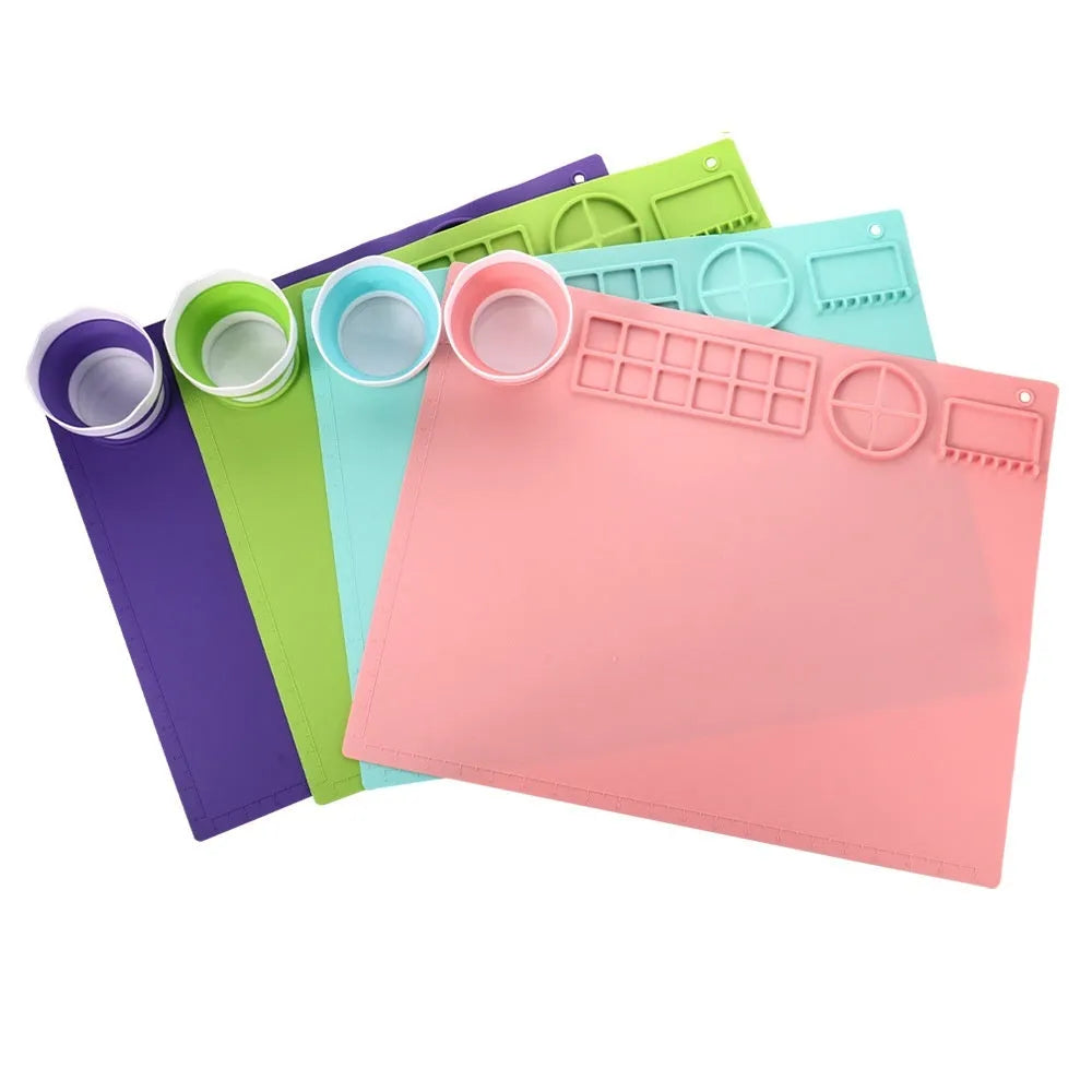 Light blue silicone painting mat with two built-in bowls, sized 50 by 40 centimetres.