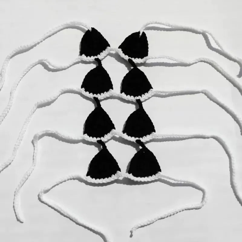 Funny black cat wearing a lace bikini and bra costume for Halloween or cosplay.