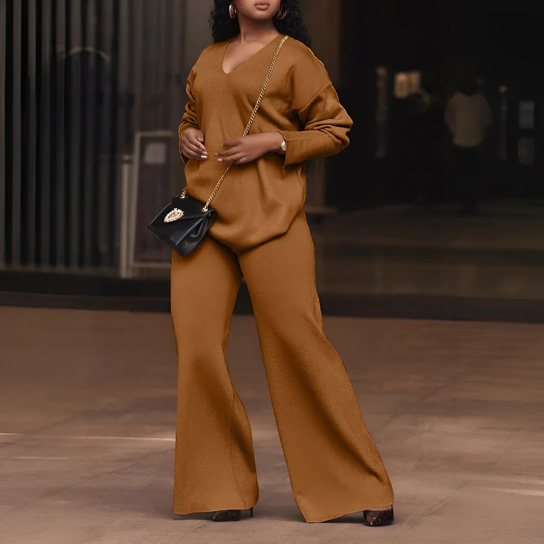 Women's brown suede velvet two-piece casual suit with long sleeves and trousers on a hanger.