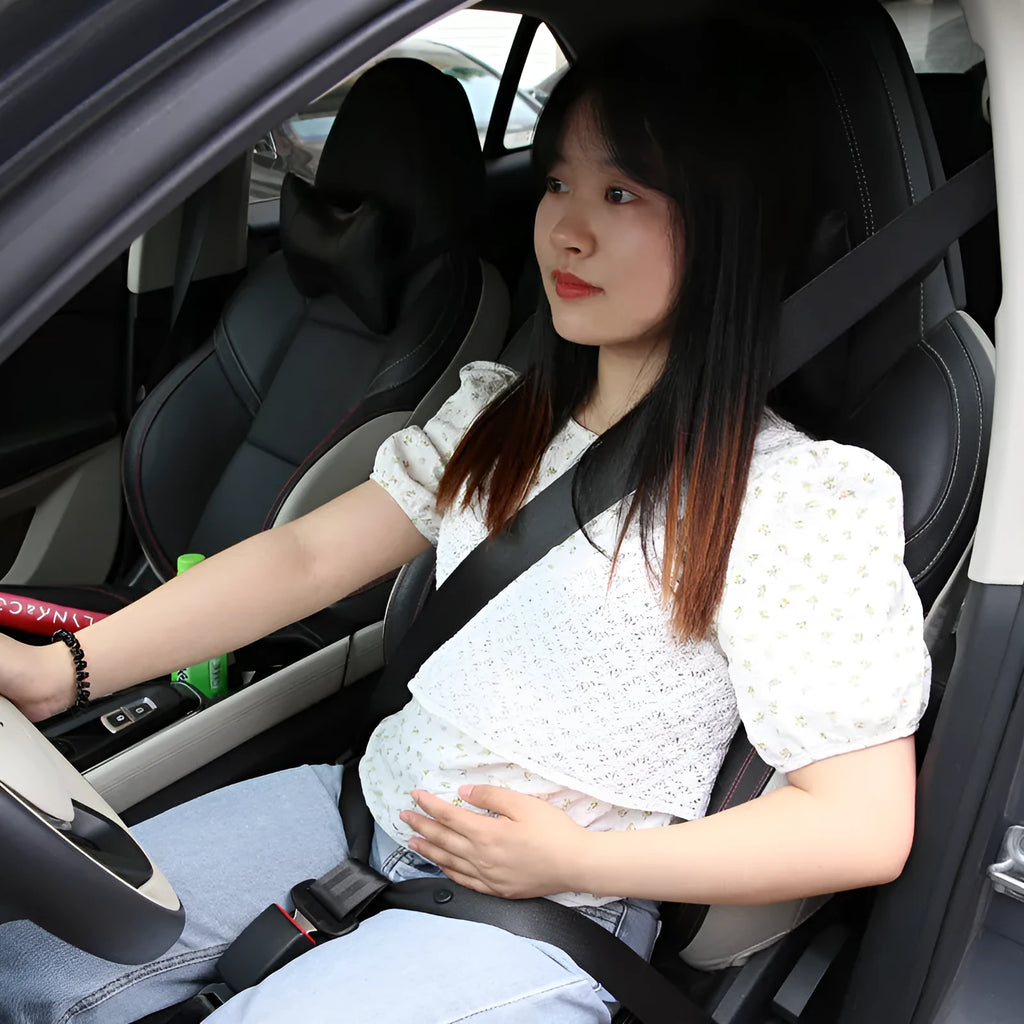 Pregnant women's adjustable car seat belt support in black with press-stud buckle, shown wrapped around a car seat.