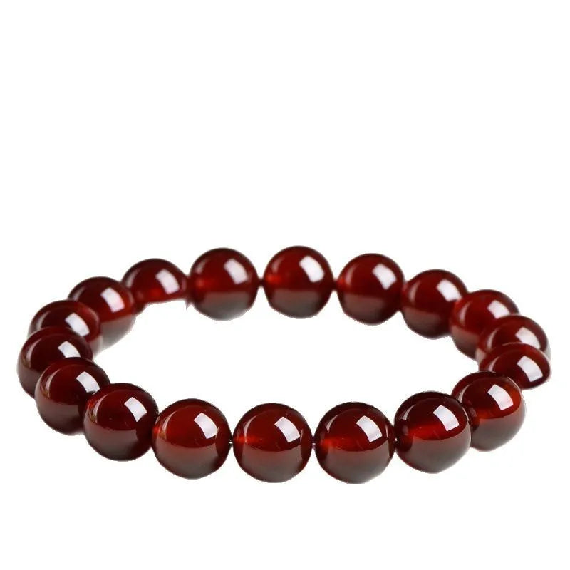 Natural orange red garnet ball bracelet with Ruyi beads on a wrist, showing unisex retro crystal jewellery.