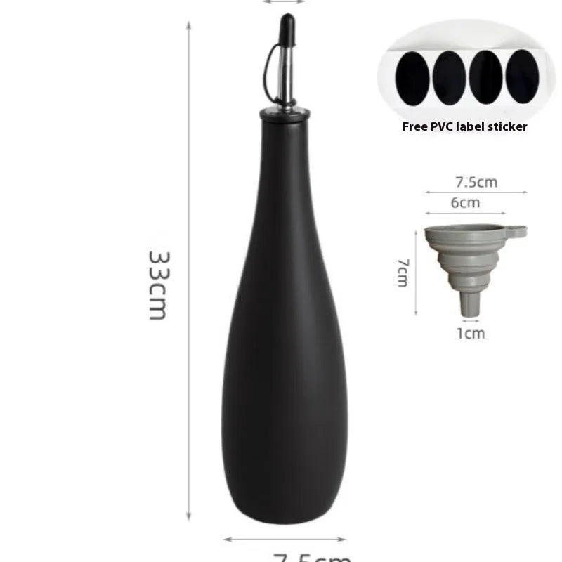 Black conical ceramic oil pot with funnel top and oil brush on a kitchen counter.