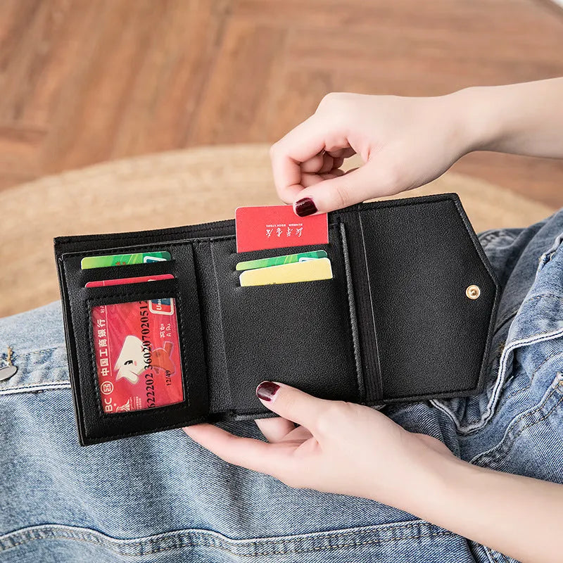 Ladies tri-fold PU leather wallet with magnetic buckle, card slots, ID space, coin pocket, and heart decoration