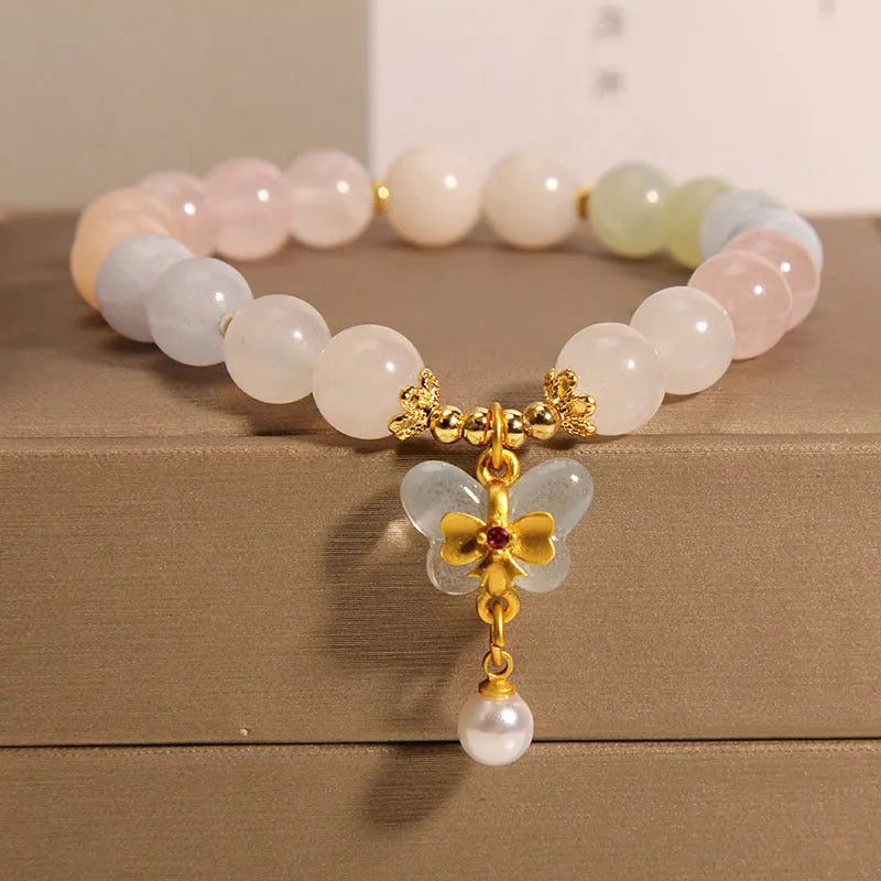 Women's adjustable crystal bracelet with a colourful morganite butterfly pendant on a white background.