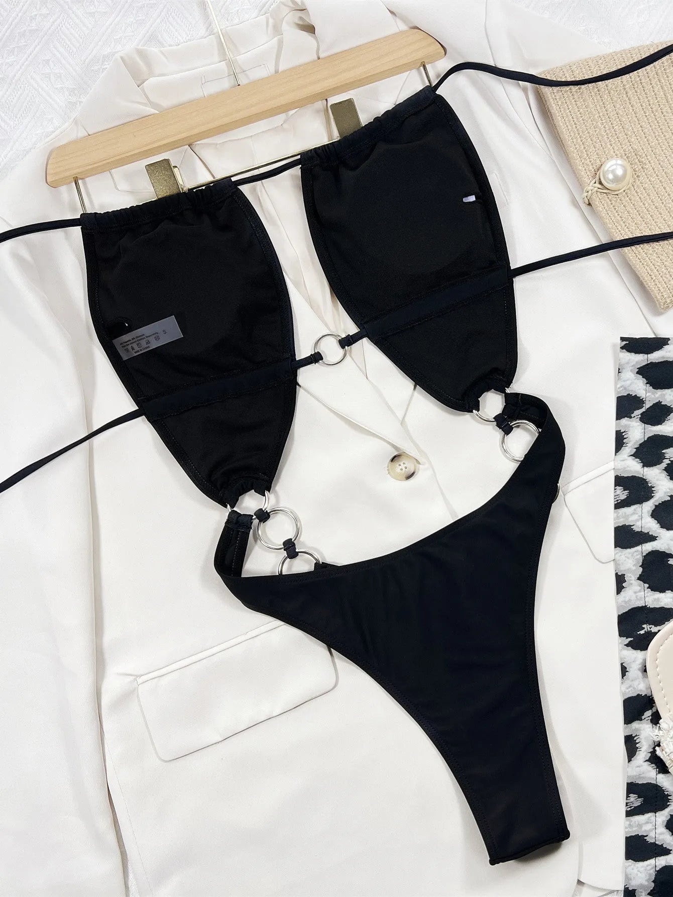 Black solid colour sleeveless one-piece swimsuit for women on a hanger.