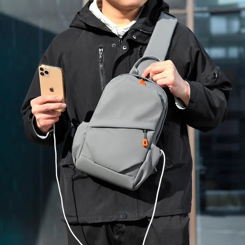 A black polyester single shoulder crossbody bag for men, shown with a model wearing it.