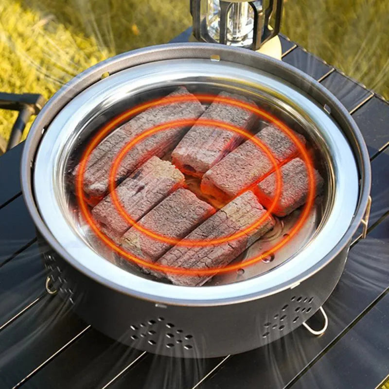 Portable stainless steel charcoal barbecue grill with removable legs and storage bag for outdoor use.