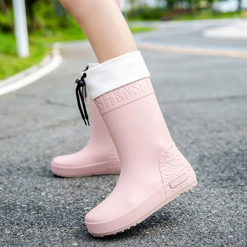 Women's solid colour PVC rain boots with non-slip sole in apricot, black, brown, or pink waterproof mouth.