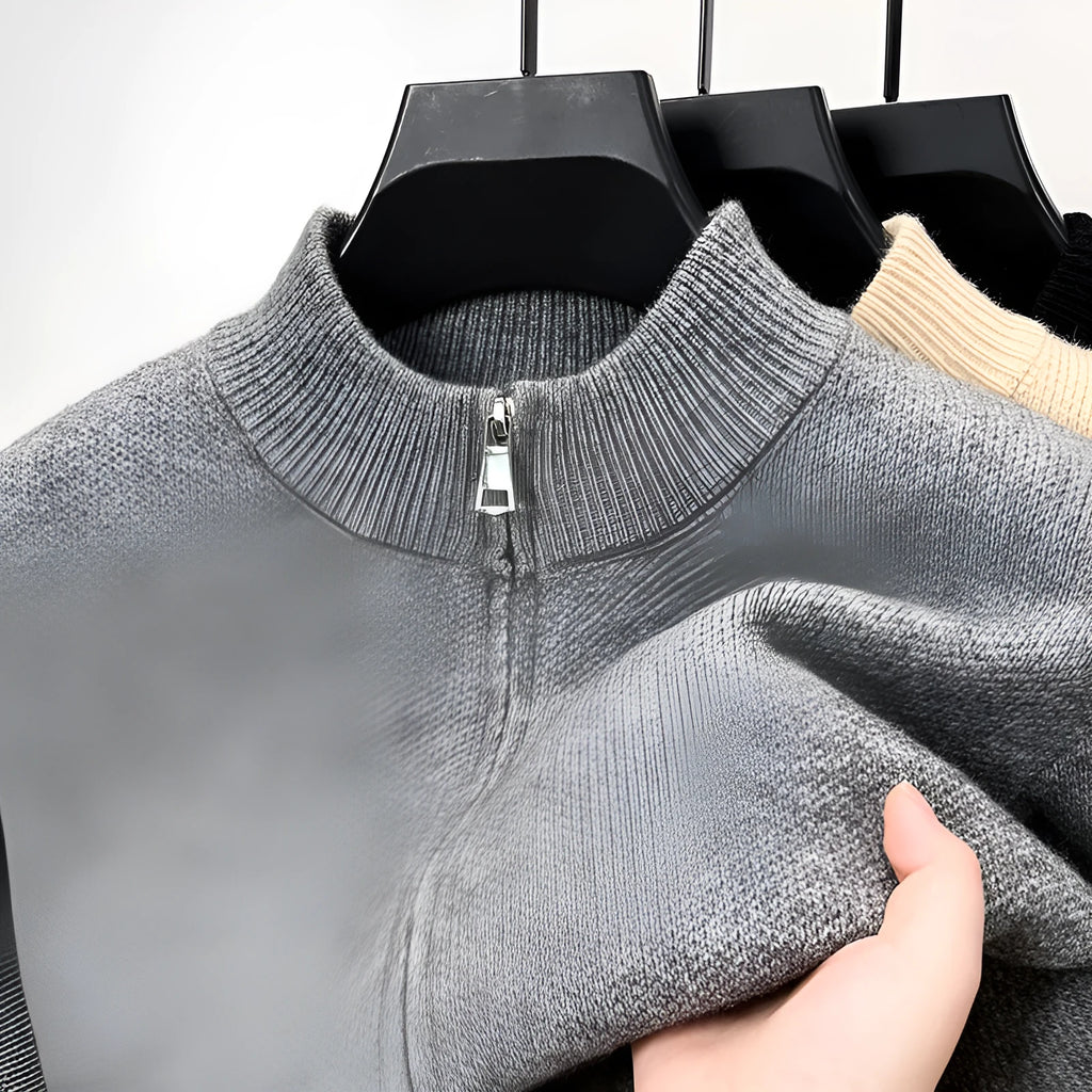 Man wearing a loose-fit, grey, stand collar knitted cardigan with a full-length front zipper.